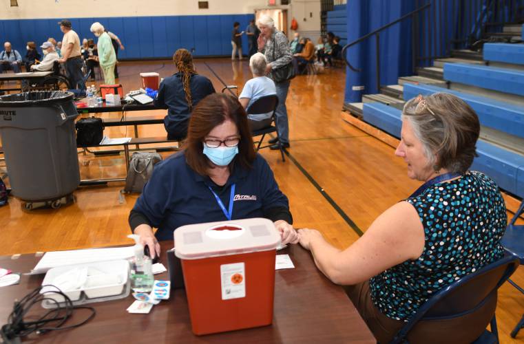Registered Nurse Cathy Marchese prepares to vaccinate Shelburne resident Carol Foote against COVID-19 at West County People Supporting People’s Community Resource Fair at Mohawk Trail Regional School last week.