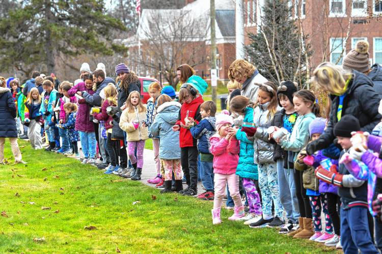 Northfield Elementary School students and staff members pass nonperishable food items from the school to the Northfield Food Pantry at Dickinson Memorial Library on Tuesday.