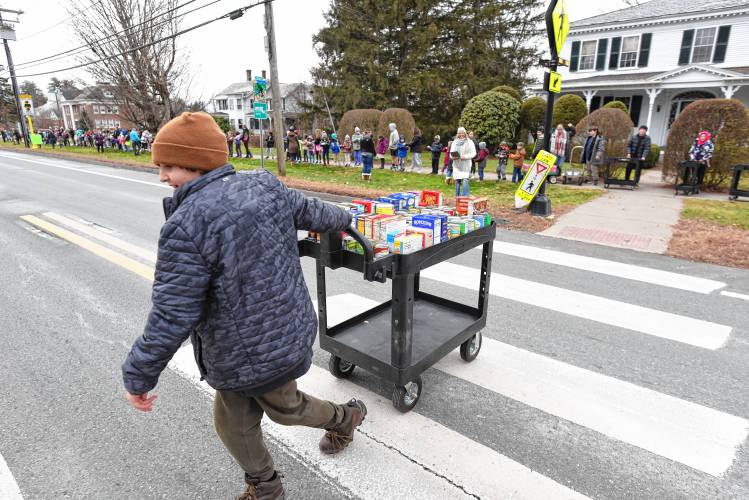 A cartful of nonperishable food is transferred across Main Street from Northfield Elementary School to the Northfield Food Pantry at Dickinson Memorial Library on Tuesday. 