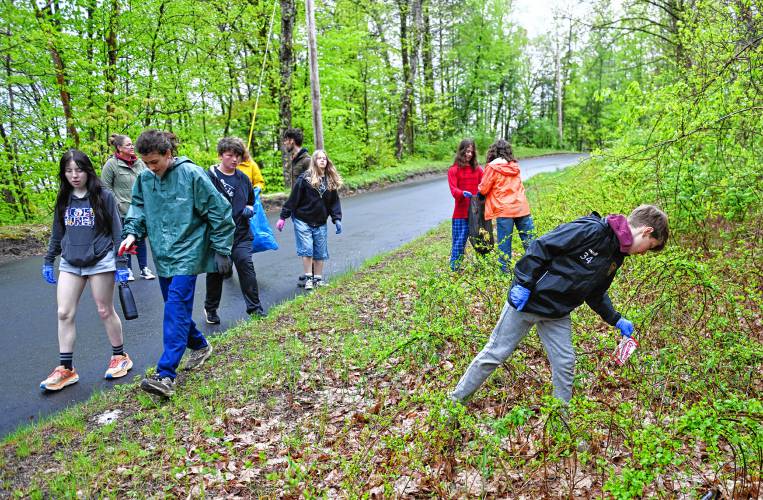 Students from Four Rivers Charter Public School pick up trash along Eunice Williams Drive in Greenfield near the covered bridge on Wednesday.