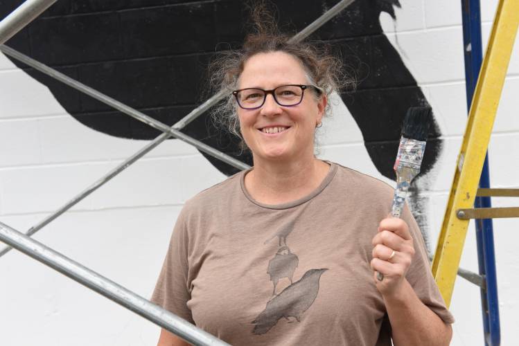 Whitney Robbins, pictured while painting a crow on the side of the Salvation Army store on Hope Street in Greenfield in 2020, will lead a Community Draw at the Greenfield Public Library on Thursday, Feb. 15.