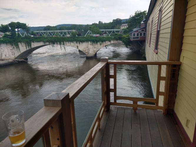 Take your date to Floodwater Brewery in Shelburne Falls to enjoy a pint and a view.alty boards hanging on the wall.