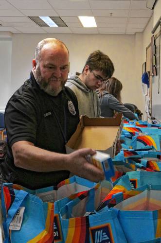 Dan Miner, school resource officer at Turners Falls High School, packs food to be distributed to as many as 22 families ahead of Thanksgiving.