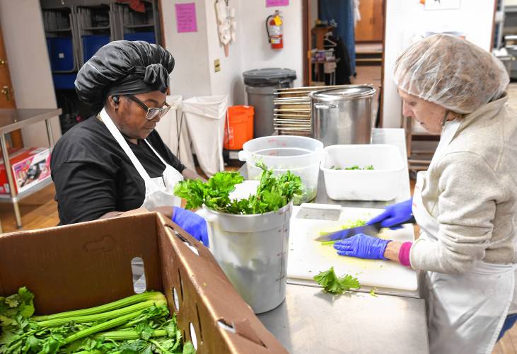 Employee Stephanie Jeffries and volunteer Janice Henderson cut up stalks of celery preparing for Thanksgiving dinner at Stone Soup Café in Greenfield.