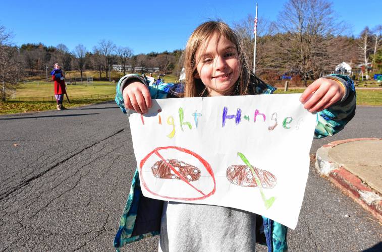 Aria Spiegel, a third grader at Conway Grammar School, holds a sign as she participates in a mini Monte’s March on Monday.