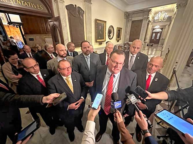 House Minority Leader Brad Jones speaks to reporters, backed by much of the House Republican caucus, after House Democrats mustered a quorum and accepted a conference report on the fiscal year 2023 closeout budget on Monday. 