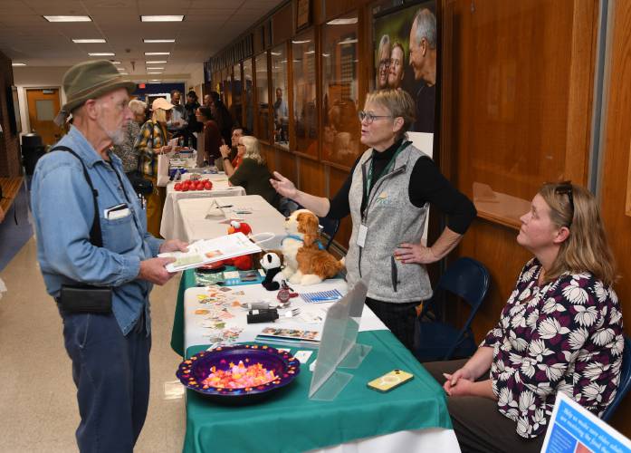 Conway resident Hank Horstmann talks with Jennifer Summers and Katie Fiander of UCP of Western Massachusetts at West County People Supporting People’s Community Resource Fair at Mohawk Trail Regional School last week.
